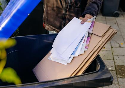 Oud papier wordt in de kliko gegooid 