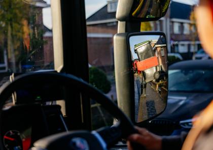 In de cabine van de vuilniswagen met de chauffeur