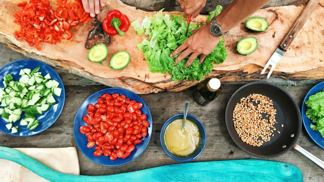 Voorbereiden van het koken van een maaltijd met allerlei ingrediënten op een snijplank en in bakjes.